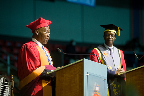 South African writer Mandla Langa accepting his honorary doctorate from the University of Pretoria as Vice-Chancellor Professor Tawana Kupe looks on.