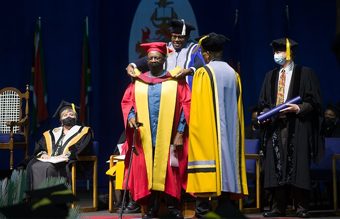 Professor Mokubung Nkomo on stage receiving his honorary doctorate at a graduation ceremony held at the University of Pretoria.