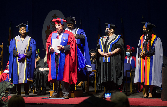 Professor Sijbren Cnossen on stage receiving his Honorary Doctorate (honoris causa) in Commerce at a University of Pretoria graduation ceremony.