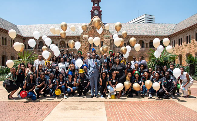 A large group of University of Pretoria students pose for a picture with Vice-Chancellor and Principal Professor Tawana Kupe outside the Old Arts Building on the University's Hatfield Campus.
