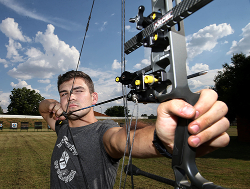 Christian de Klerk aiming at at unseen target as he gets ready to take a shot with a bow and arrow