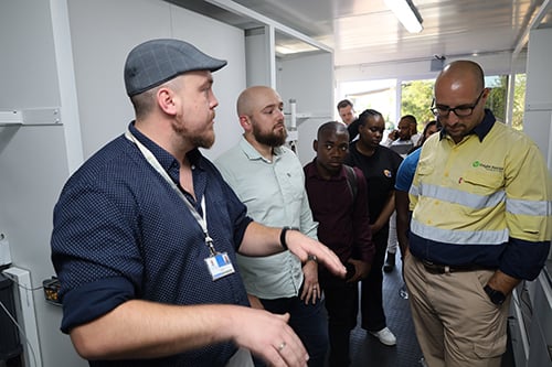Mobile laboratory coordinator Vian Venter shows guests around the facility.