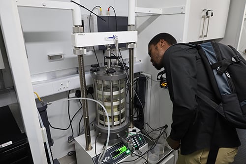 A triaxial test on a soil sample with local strain measurement and bender element testing underway.