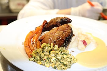 roasted smoked pork cheek with a garlic rub, served with charred onion potato mash, fondant carrot, a fresh corn salad and apple beurre blanc (a white wine reduction)