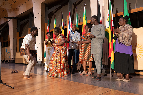 Ghanaian fellows and training participants celebrating and dancing on stage at one of the networking dinners held during the stakeholder engagement dialogue.