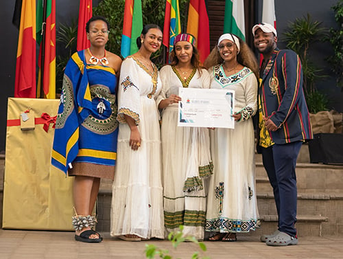 Students representing Ethiopia and the Kingdom of Eswatini who won first and second place, respectively, in the exhibitions category pose on stage
