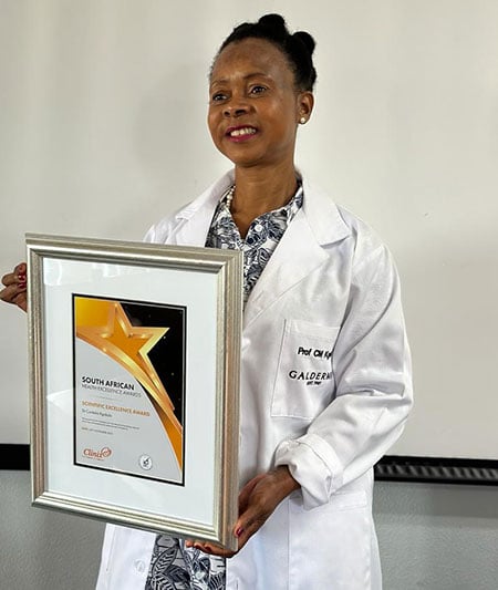 Professor Mahlatse Kgokolo, in a white lab coat, poses with her award