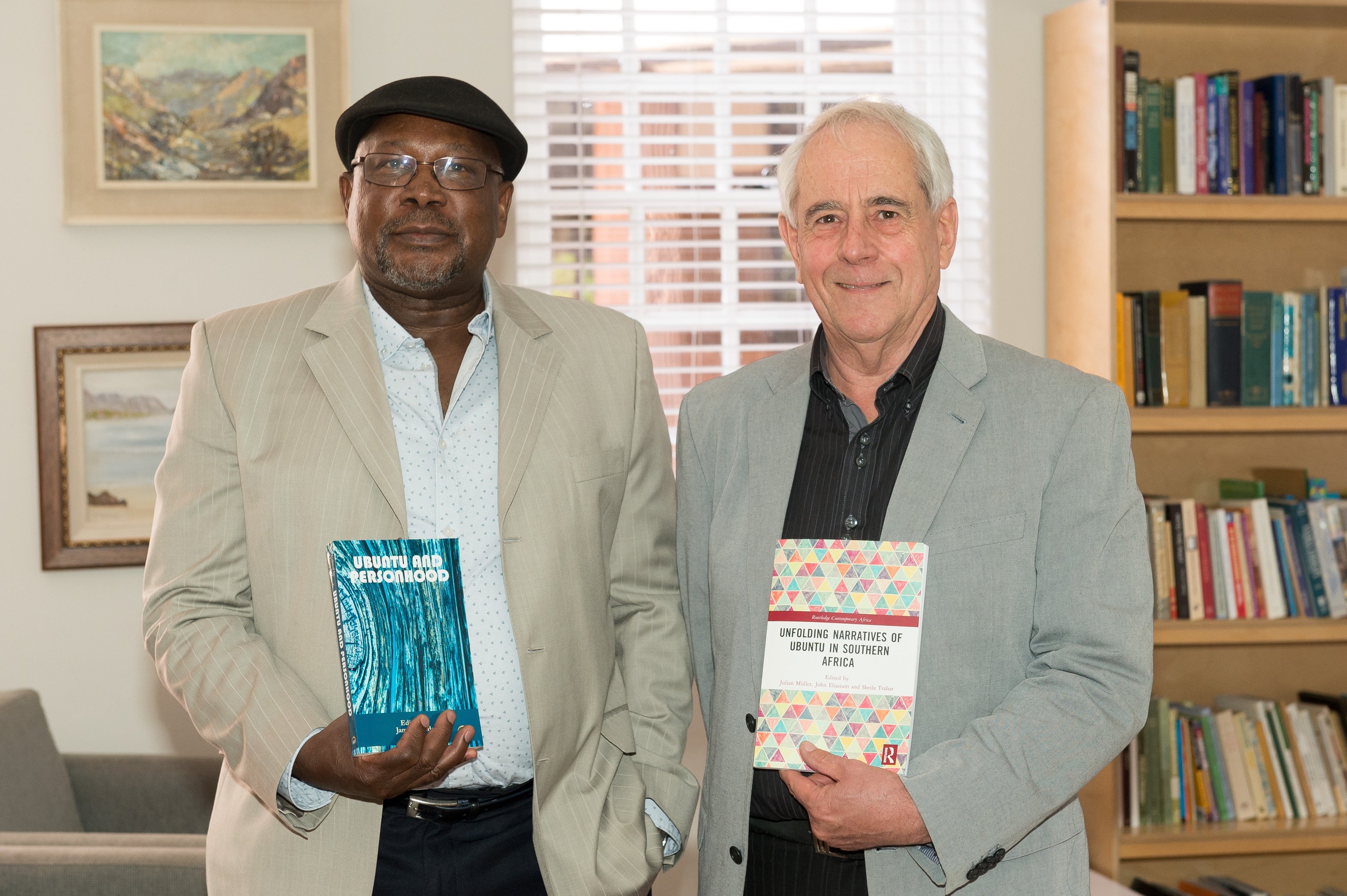 Professors James Ogude and Julian Muller (l-r) with the first books published in the Ubuntu Project. 