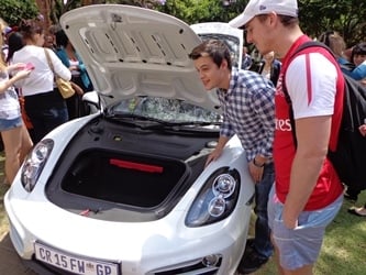 Marketing students viewing the Porsches on display.